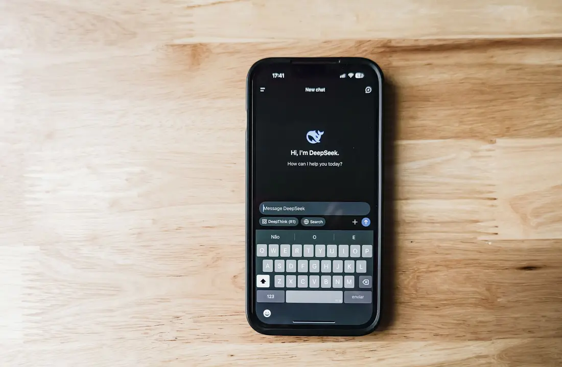 A smartphone on a wooden table showing an AI chatbot interface called DeepSeek.