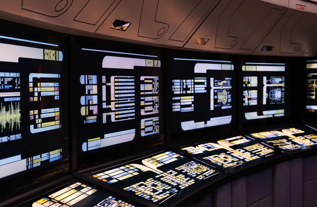 A high-tech command center with illuminated digital screens in a futuristic setting.