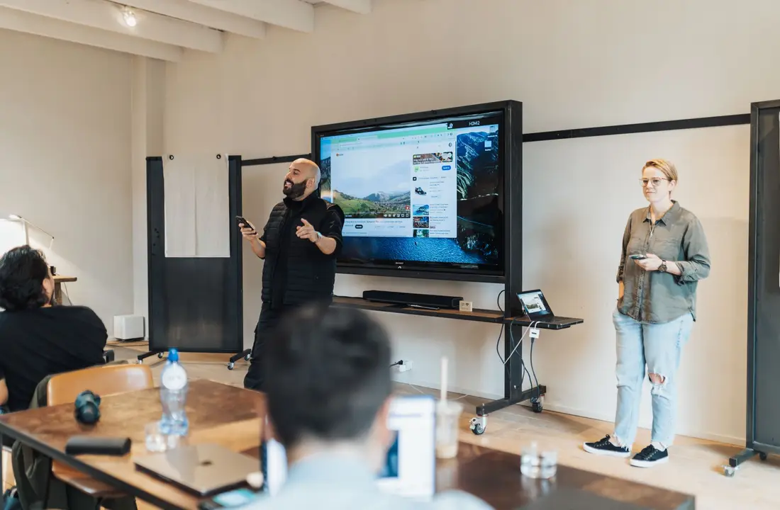 A team presentation in an office with a screen showcasing work-related material.