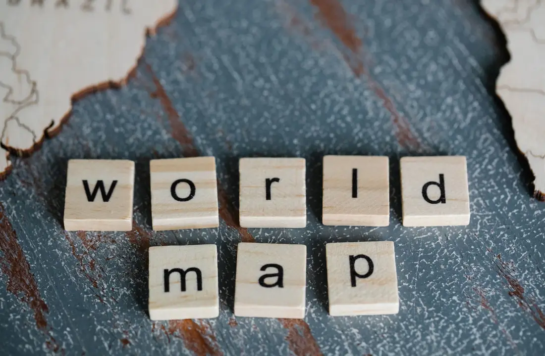 Des lettres formant les mots « world map » sur une surface en bois