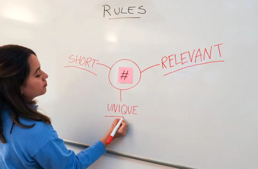 Une personne détaillant des règles marketing sur un tableau blanc
